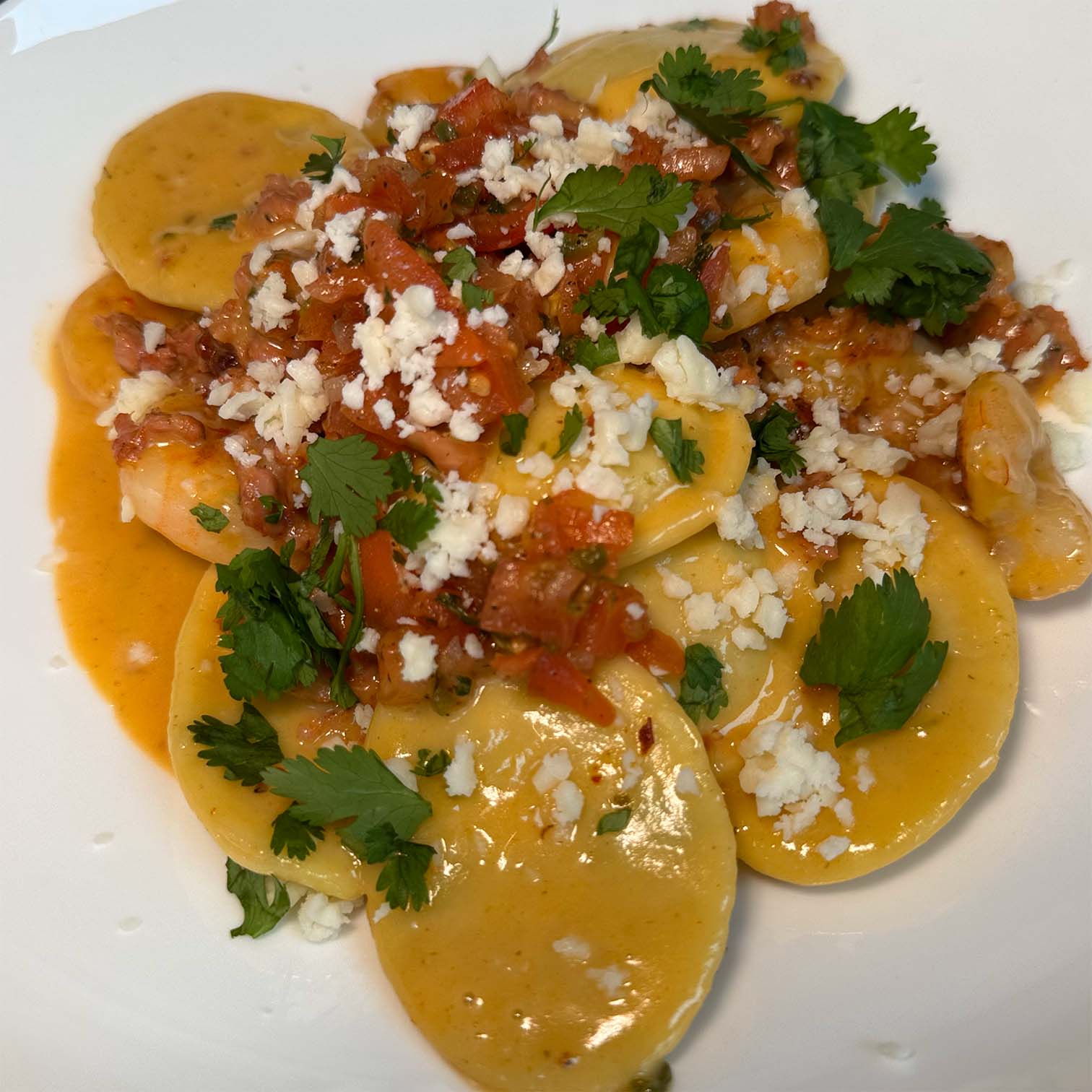 Celentano Poblano and Smoked Gouda Ravioli with Shrimp Pico de Gallo, Chorizo, Queso Sauce, Cotija, Cilantro