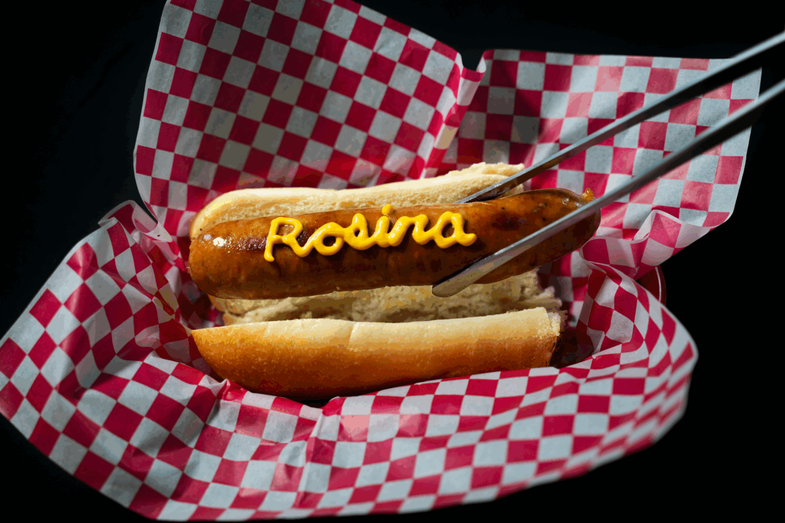 hot dog with 'Rosina' written on top with mustard